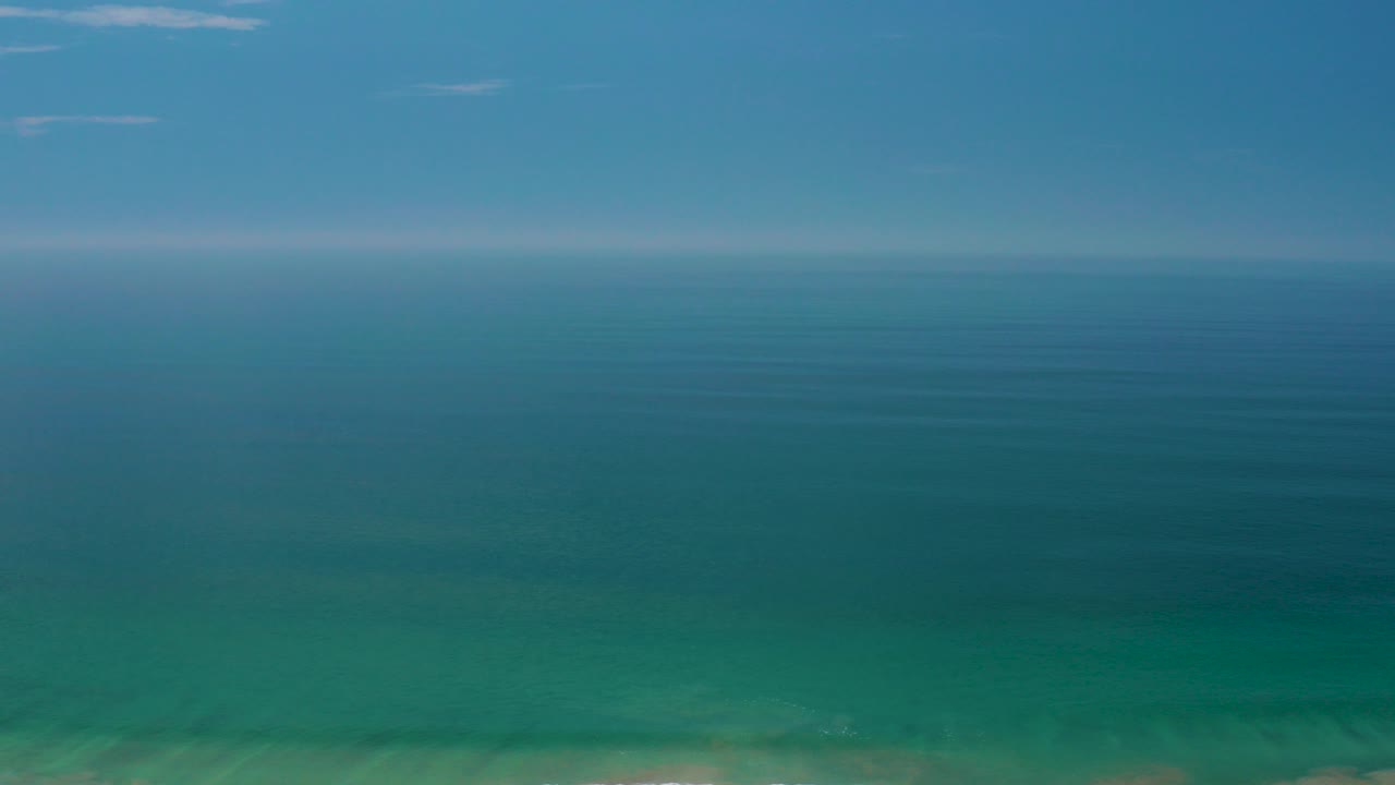 Blue-green ocean meeting a pale blue sky at the horizon.