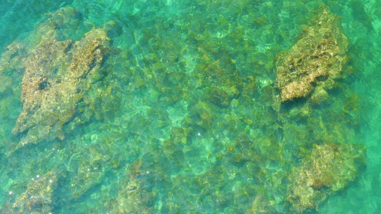 Clear turquoise water over submerged rocks
