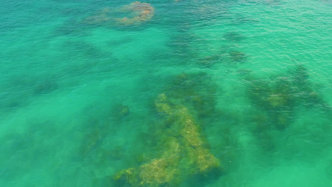 Rippling turquoise water with underwater rock shapes
