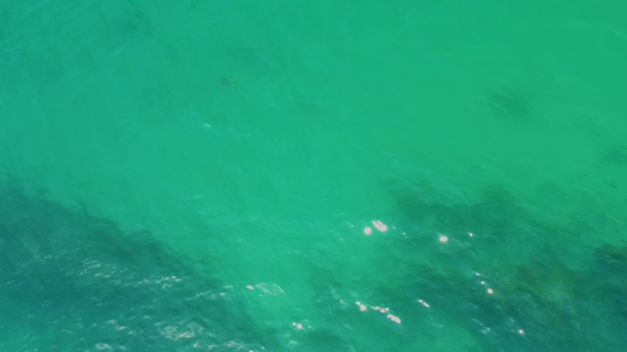 Open turquoise water with faint submerged patches