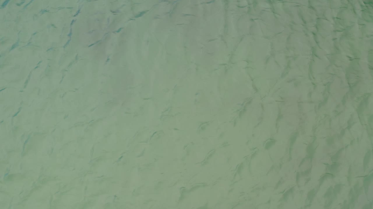 Grey green water fills the frame in La Ribera, Baja California Sur, with fine blue-green ripple marks and no shoreline, objects, or visible people.