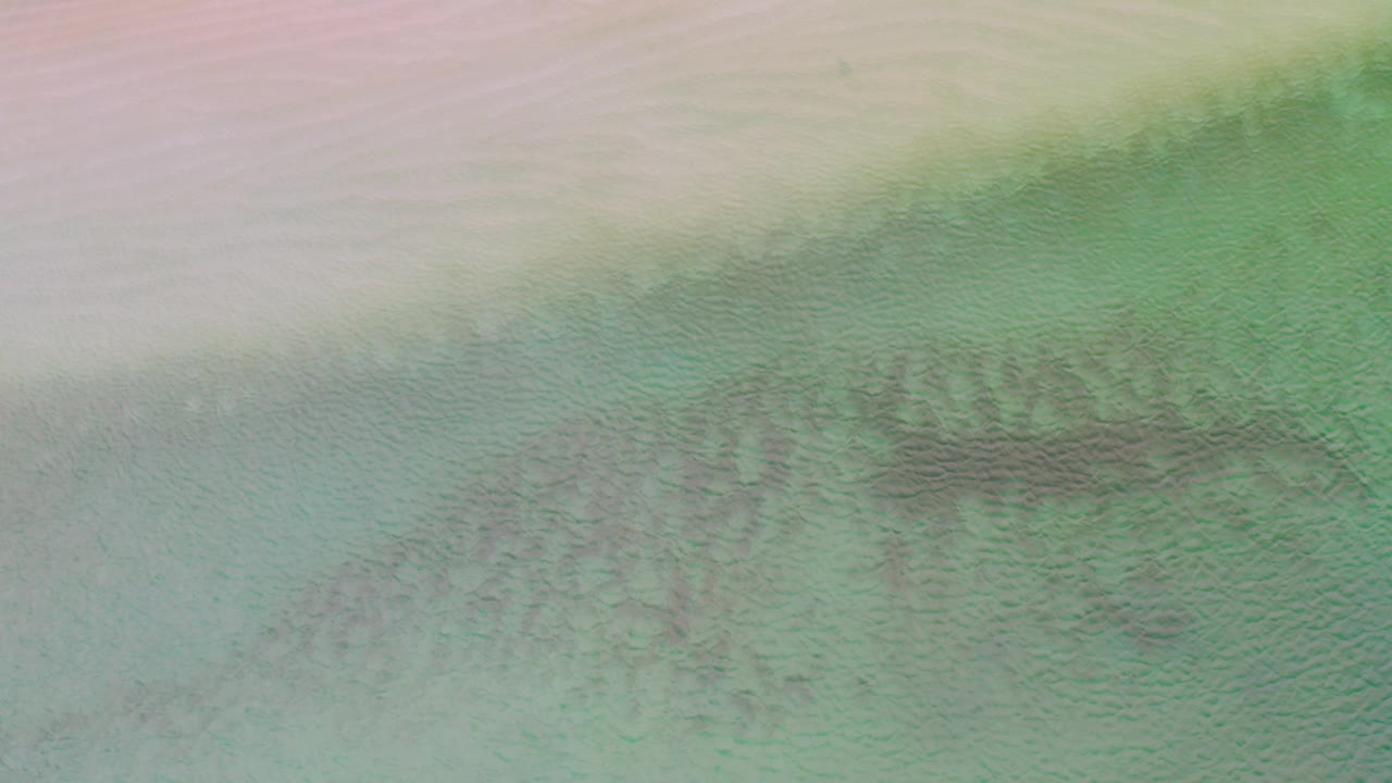 Muted sand and shallow green water with dark central sea texture