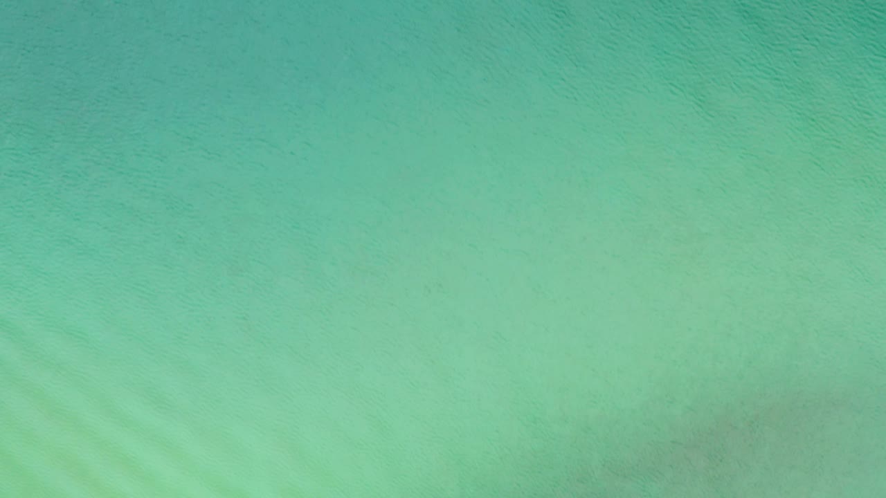 Blue-green ocean water viewed straight down in La Ribera, Baja California Sur, Mexico, with fine surface texture and no visible people.