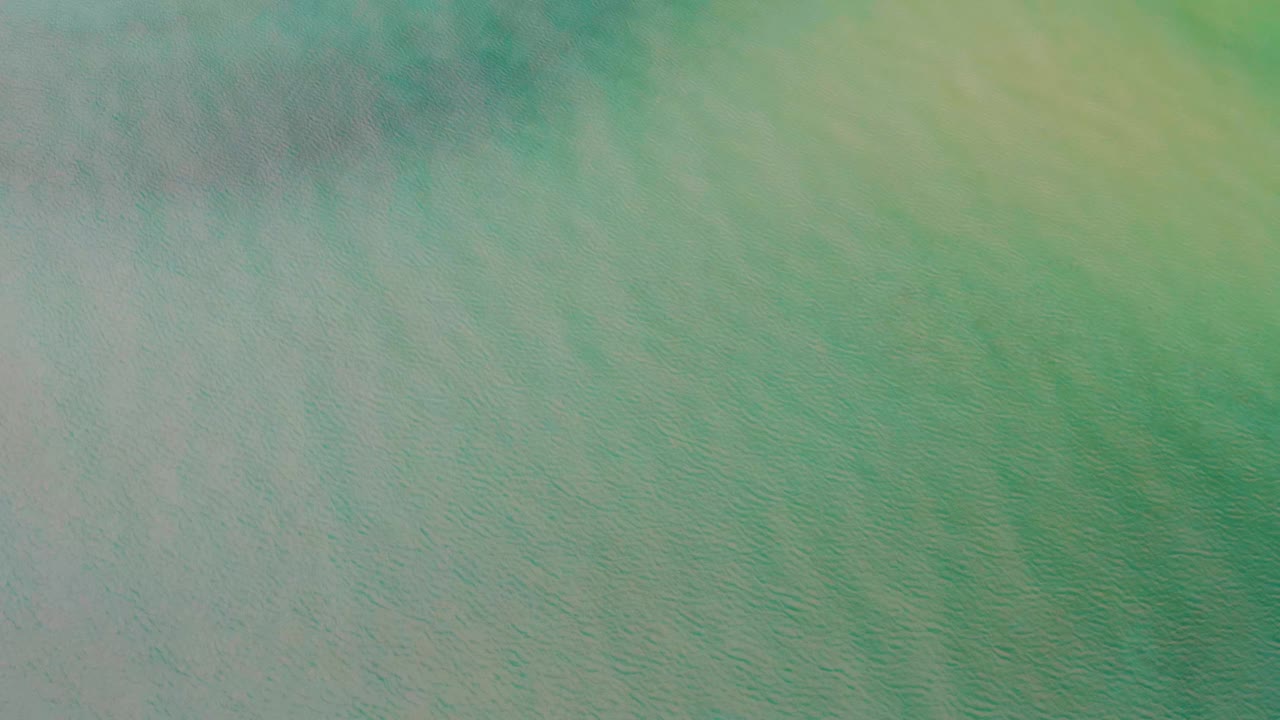 Opening frame from La Ribera, Baja California Sur showing a soft blue green abstract surface with pale yellow streaking and no visible people.