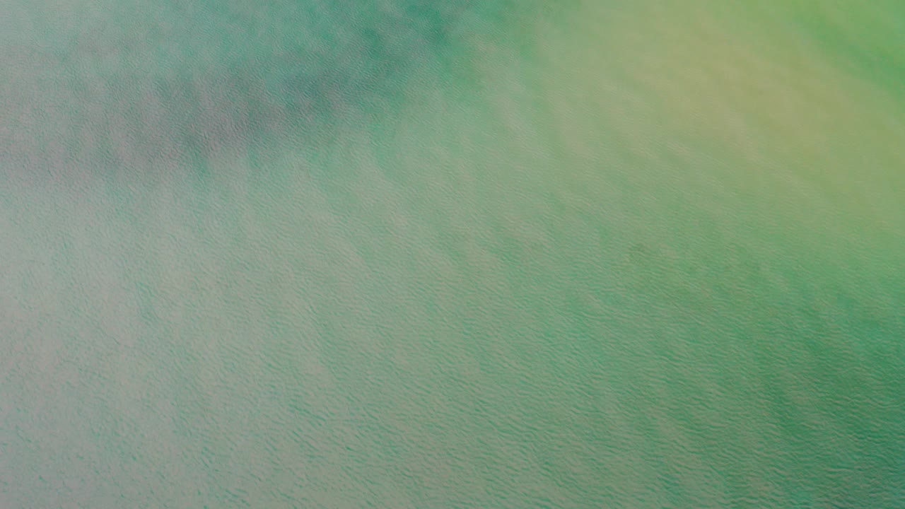 Overhead green-blue ocean water with faint ripples.