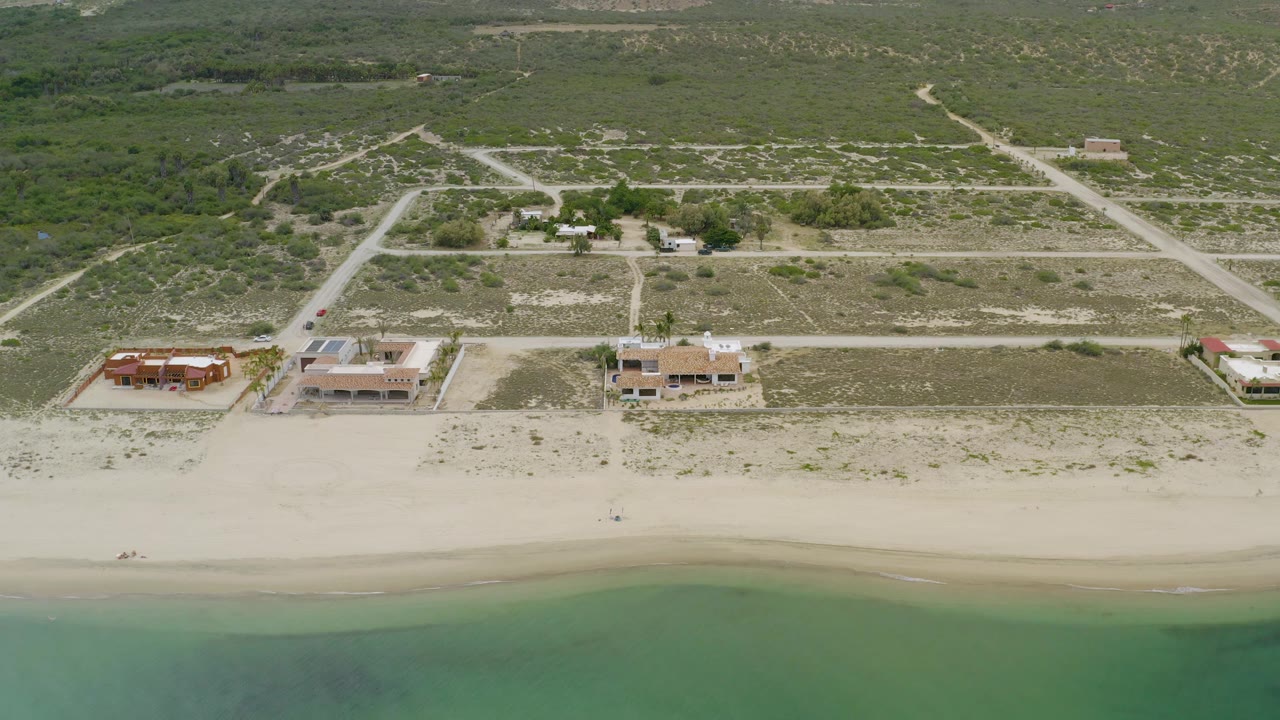 Aerial view of seaside homes and a quiet beach.