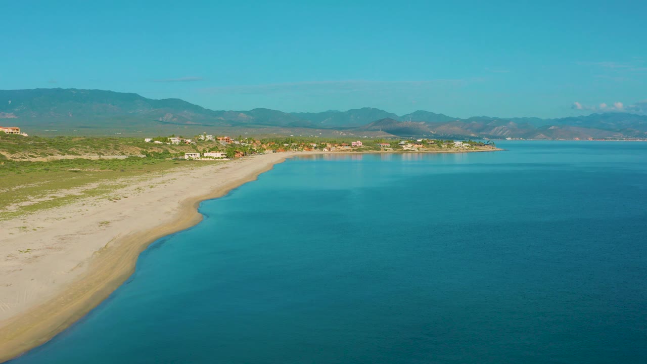 Aerial coastline with beach on the left and open blue water on the right