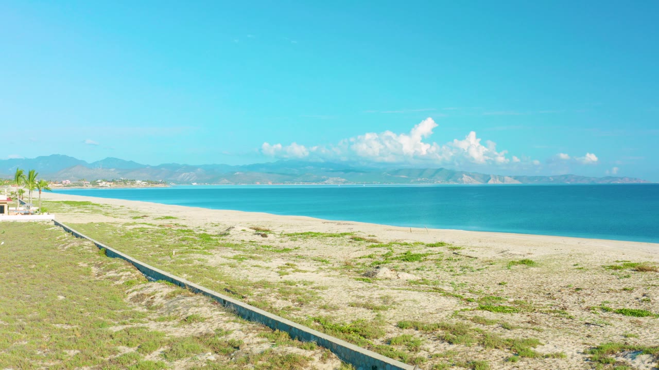 Coastal wall, beach, sea, clouds, and mountain background