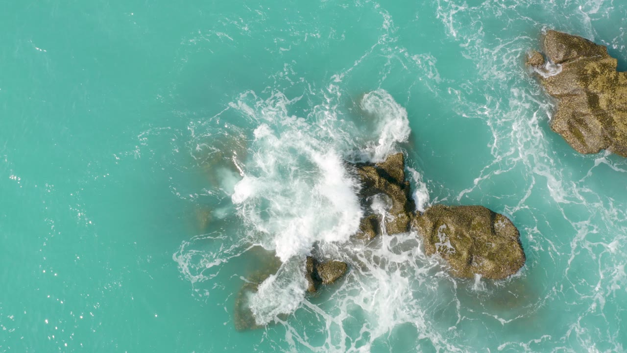 Turquoise water and white surf breaking over rocks
