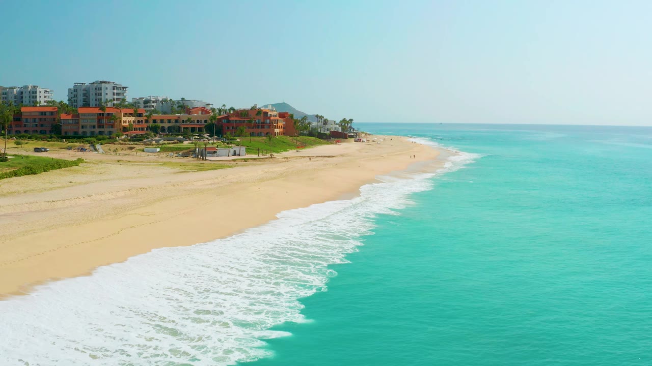 Aerial beach view with waves washing diagonally along the shore.