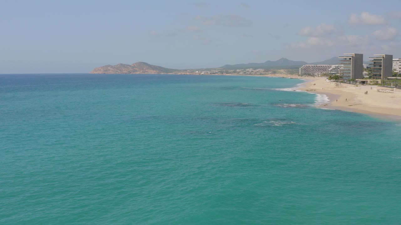 Aerial view of turquoise ocean beside a resort beach