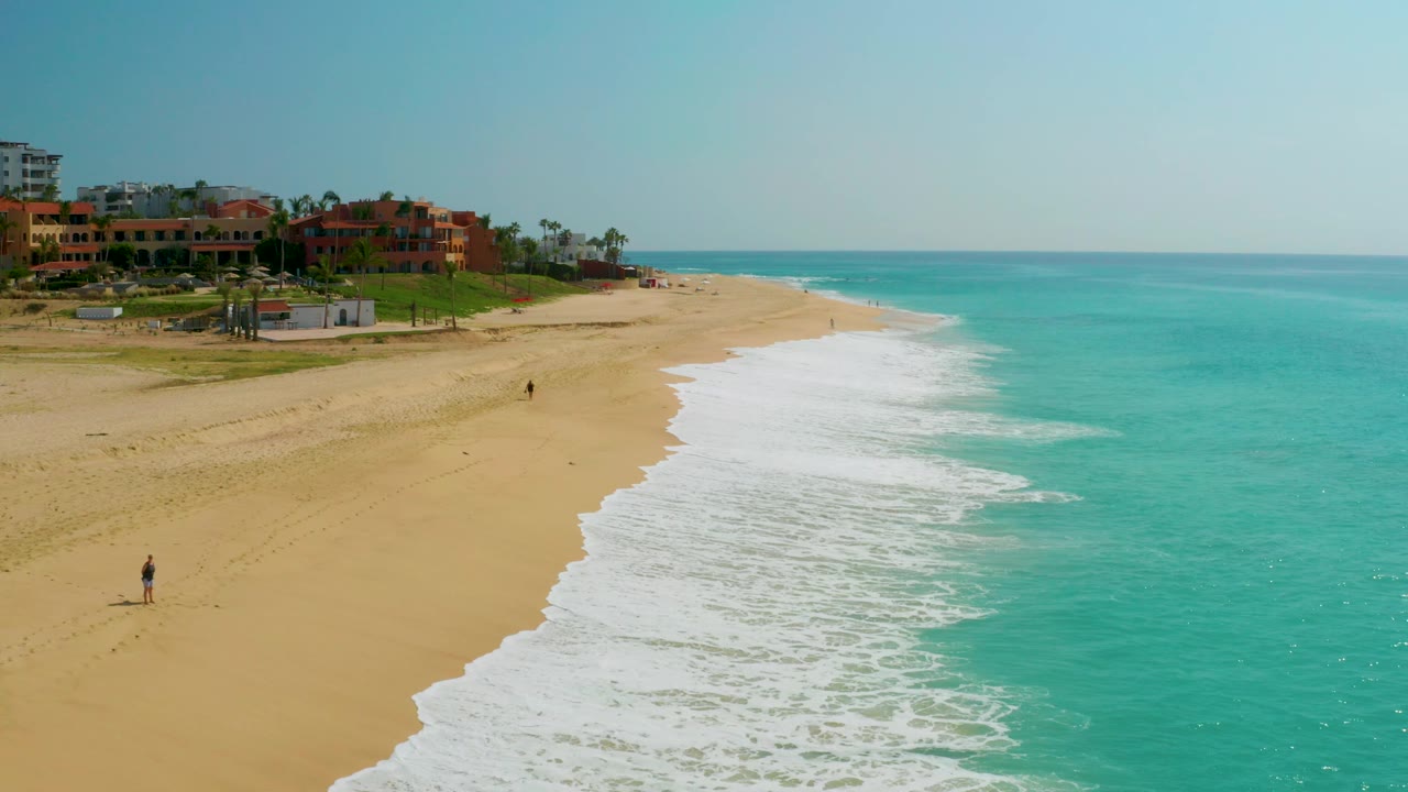 Beach resort edge with waves rolling onto sand