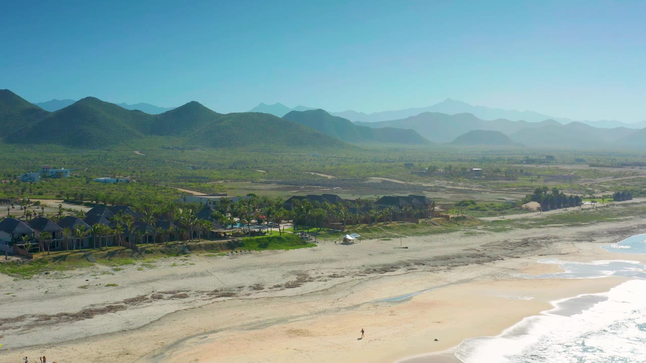 Aerial coastline with breaking waves and inland hills
