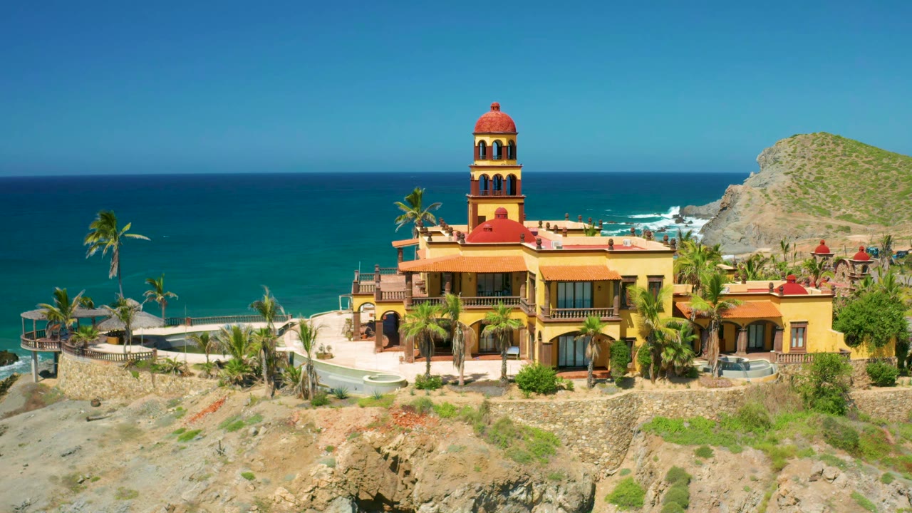 Seaside villa and palms with ocean horizon behind
