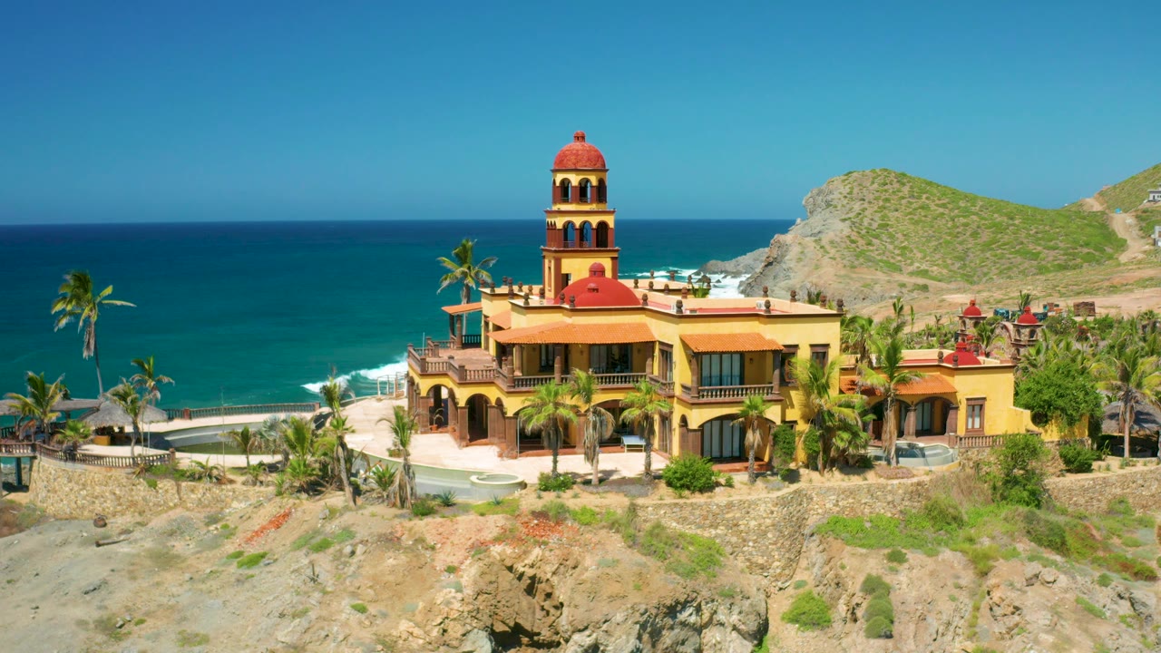Aerial view of towered seaside building and turquoise water