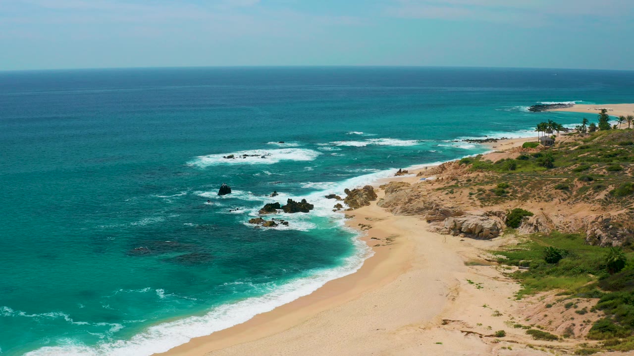 Aerial view at Secrets Marquis Los Cabos, Mexico with turquoise water, white surf, pale sand, rocky coast, and no visible people.