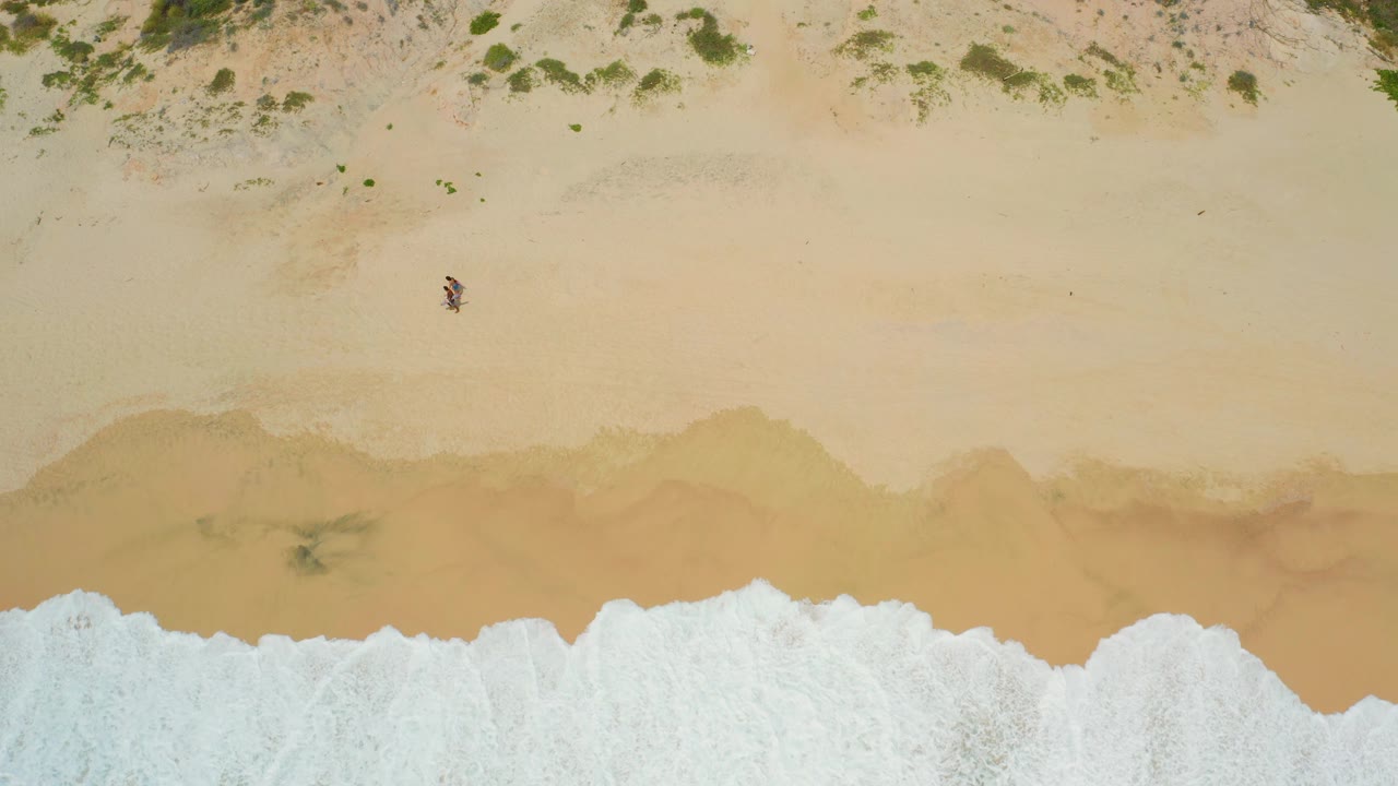 The third frame shows a wider white wave spreading across the lower part of the Secrets Marquis Los Cabos beach while one person remains alone on the dry sand above.