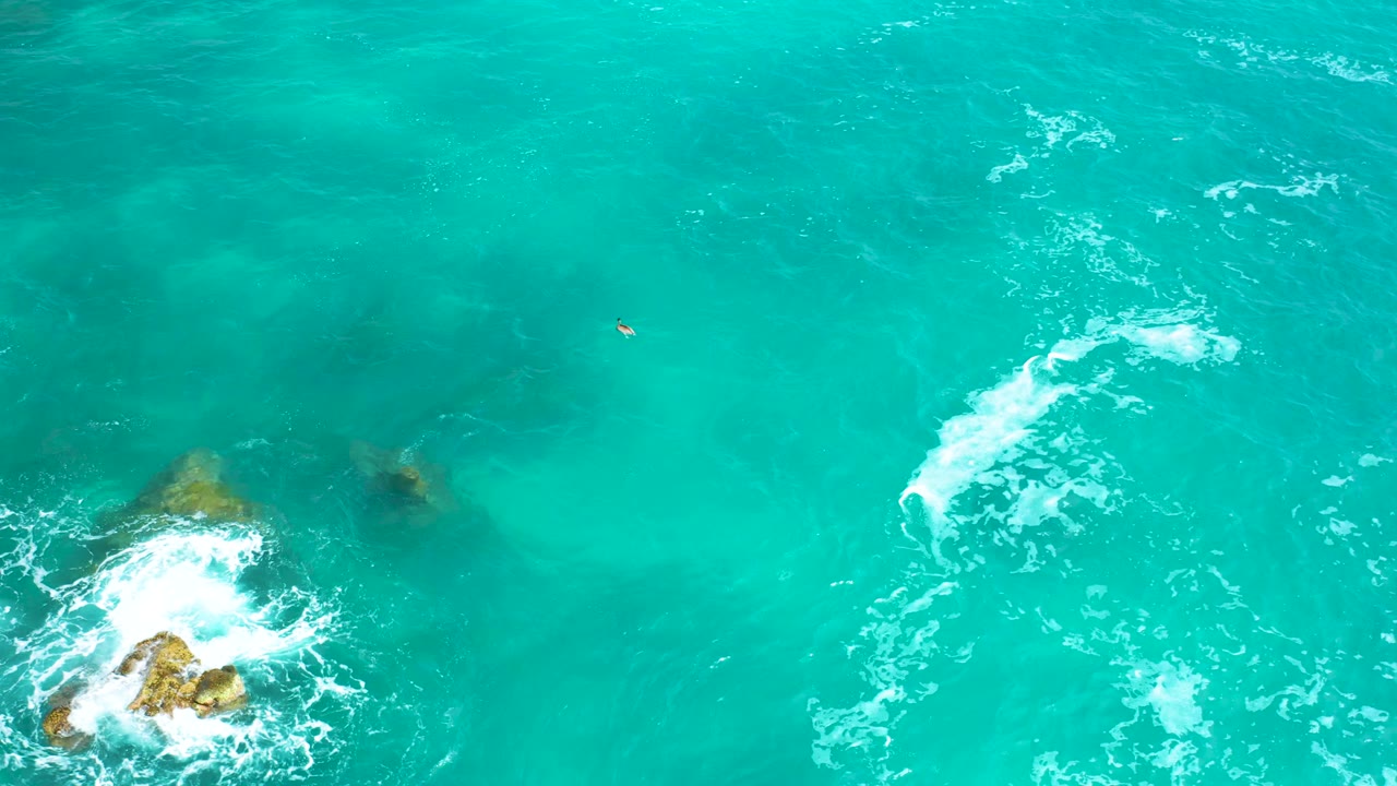 Top-down Secrets Marquis Los Cabos water frame with dark submerged rock shapes, a white foam streak along the left side, and no visible people.