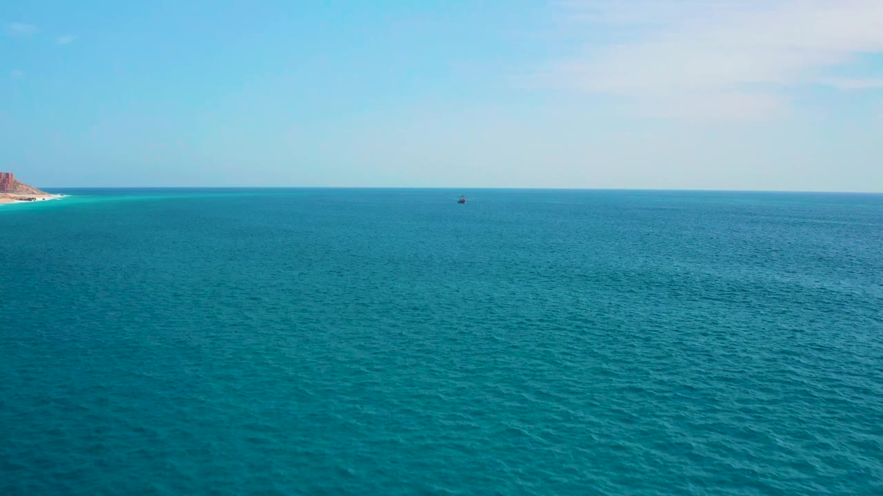 Second frame shows the same open ocean near Secrets Marquis Los Cabos, Mexico, with the rocky left shoreline slightly more present, the horizon level, a tiny distant vessel, and no visible people.