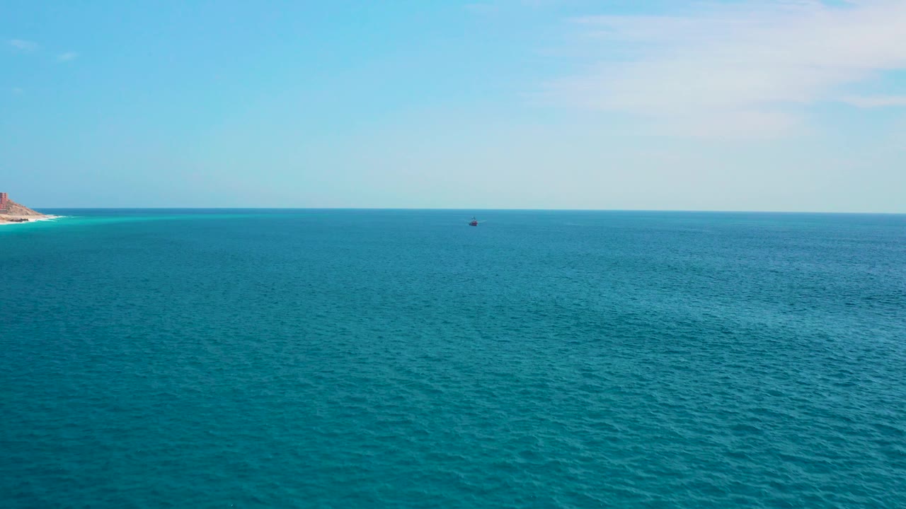 Fourth frame shows blue ocean near Secrets Marquis Los Cabos, Mexico, with more textured water in the foreground, the left coastline barely inside frame, a small dark vessel near the horizon, and no visible people.