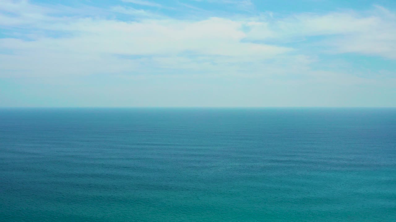 Wide view of the ocean horizon at Secrets Marquis Los Cabos, Mexico, with deep blue water below a pale clouded sky and no visible people.