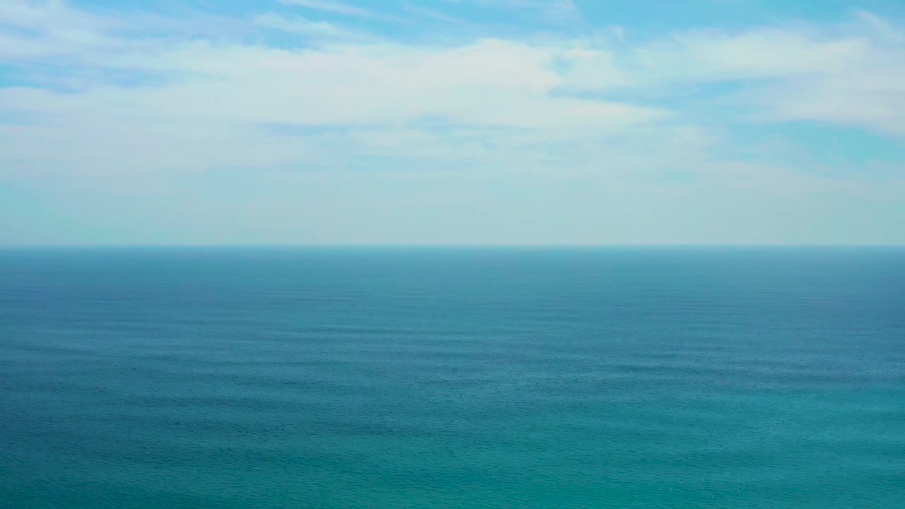 Blue ocean surface stretching to a level horizon.