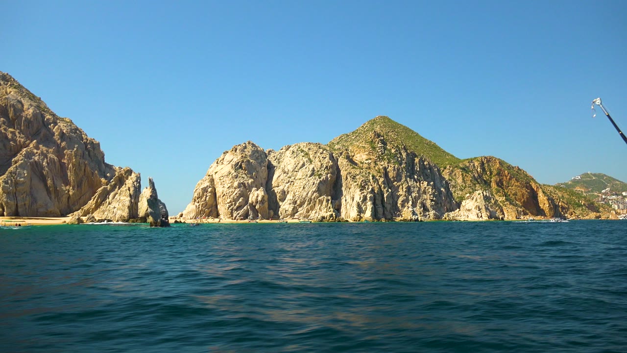 Rock formations and water with a fishing rod at the right edge.