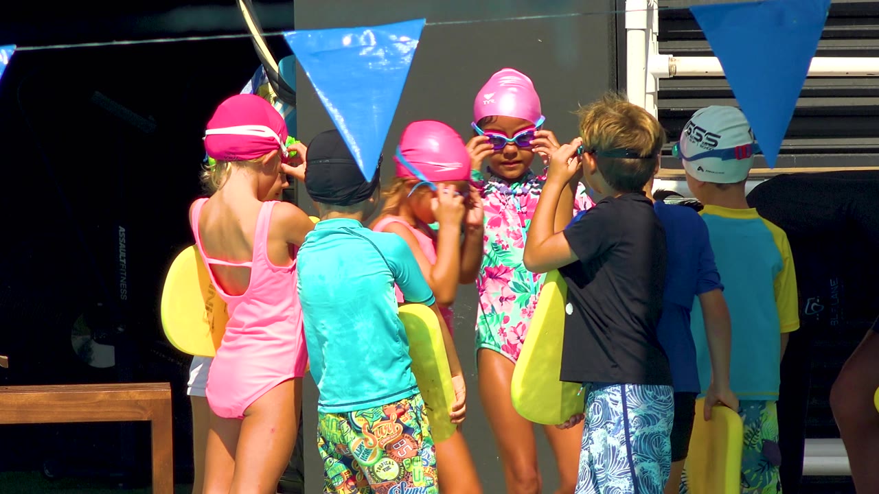 In Cabo San Lucas, more children are visible in the poolside cluster, including a child facing camera in a pink cap and sunglasses while others hold kickboards.