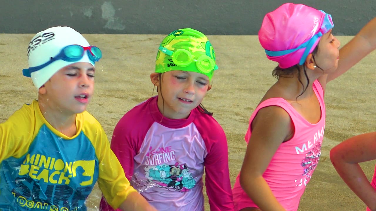 Three children in Cabo San Lucas remain tightly framed, with the pink-capped girl extending her arm and the other two facing camera.