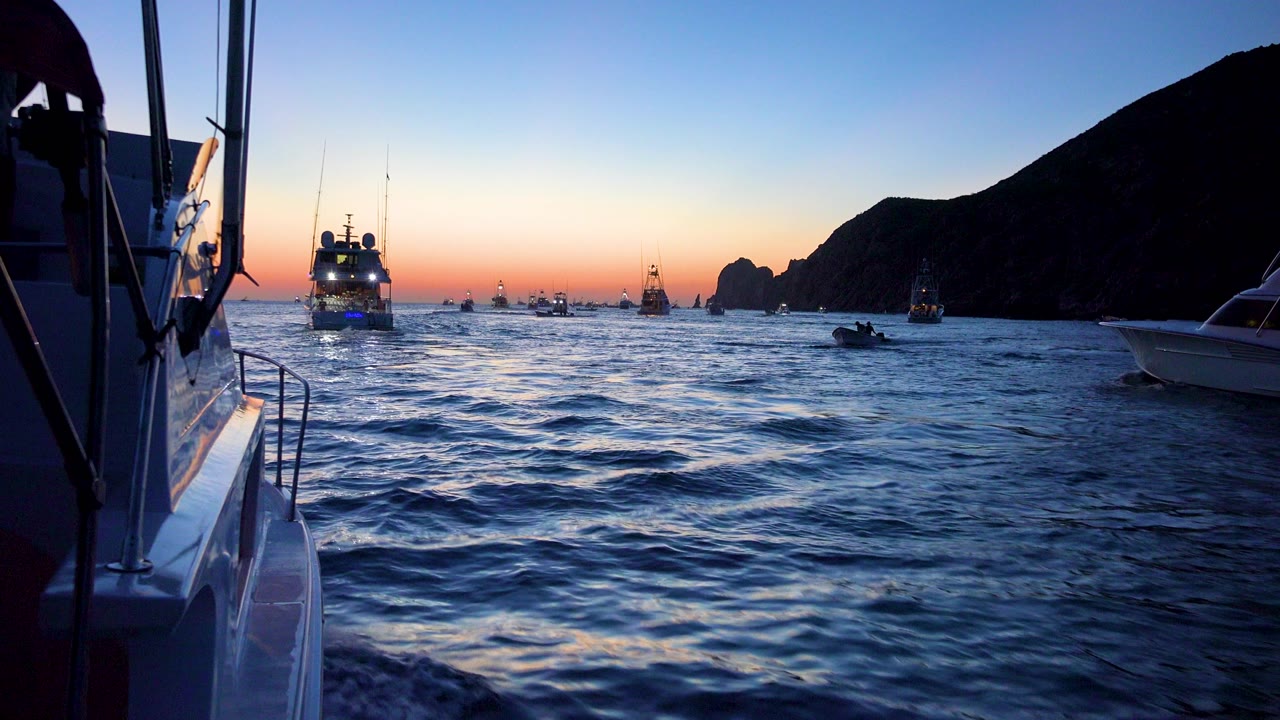Distant boats and small craft on ocean at dusk.