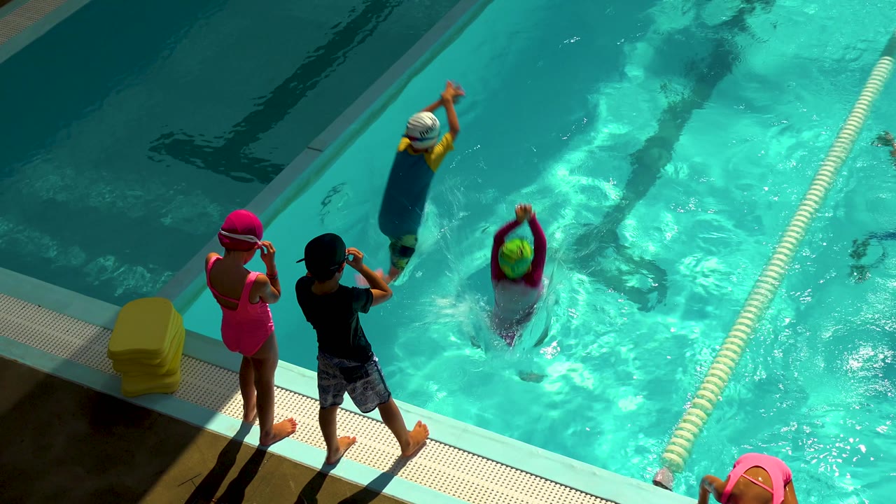 A similar high-angle Cabo San Lucas pool moment shows two children standing on the deck, a swimmer with a kickboard near the center, and bright sun reflecting across the water.