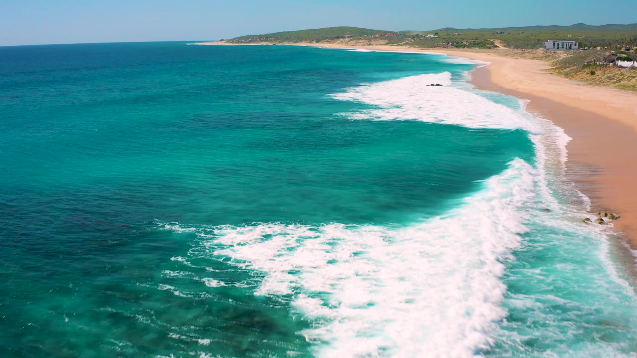 Foamy waves washing along a long sandy shoreline