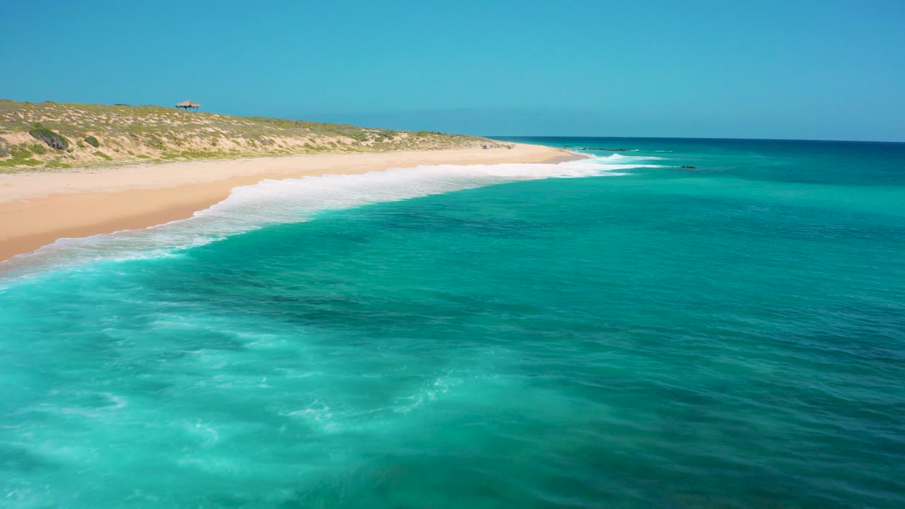 Aerial view of turquoise water and a long sandy beach