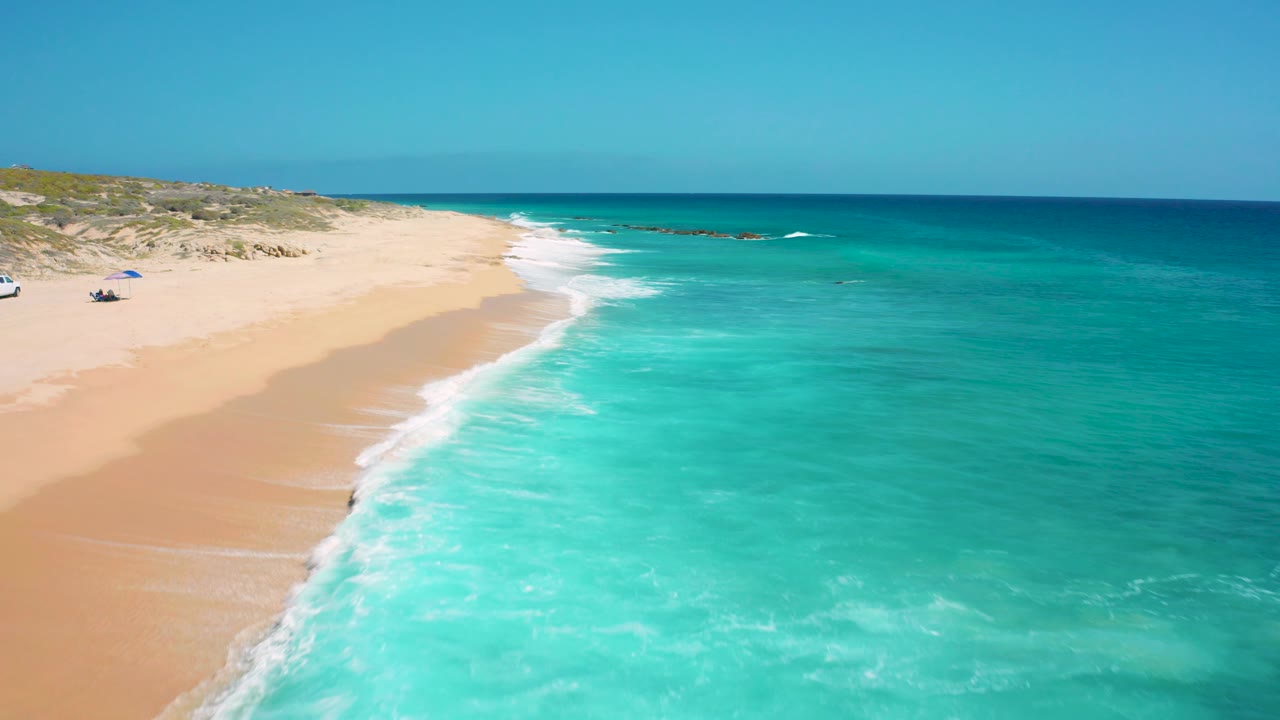 Open beach and clear turquoise water seen from above