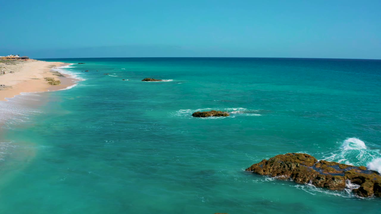 Aerial coastline with clear water and surf around rocks