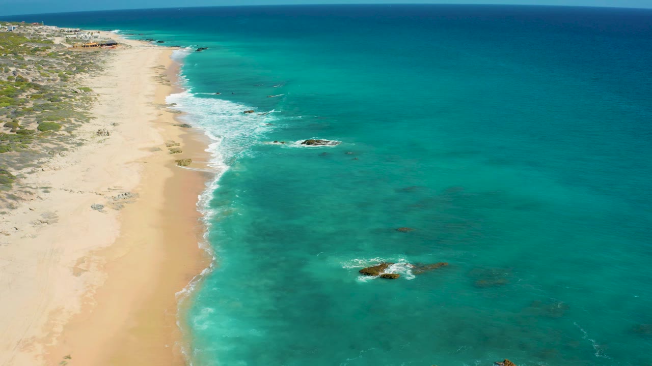 Aerial shoreline with pale sand and blue-green water