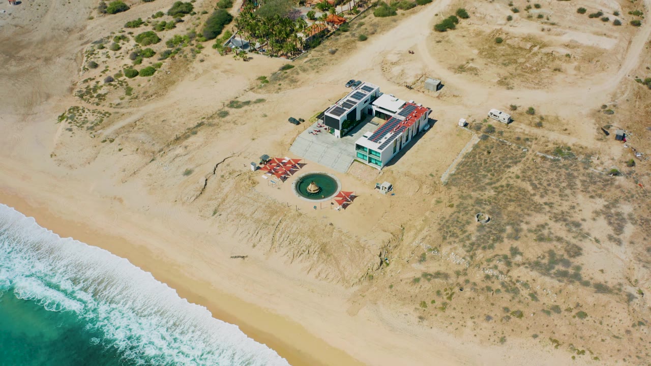 Overhead view of modern beachfront property beside surf