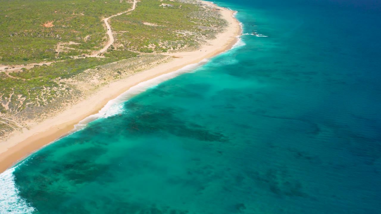 Beach edge with white waves and clear coastal water