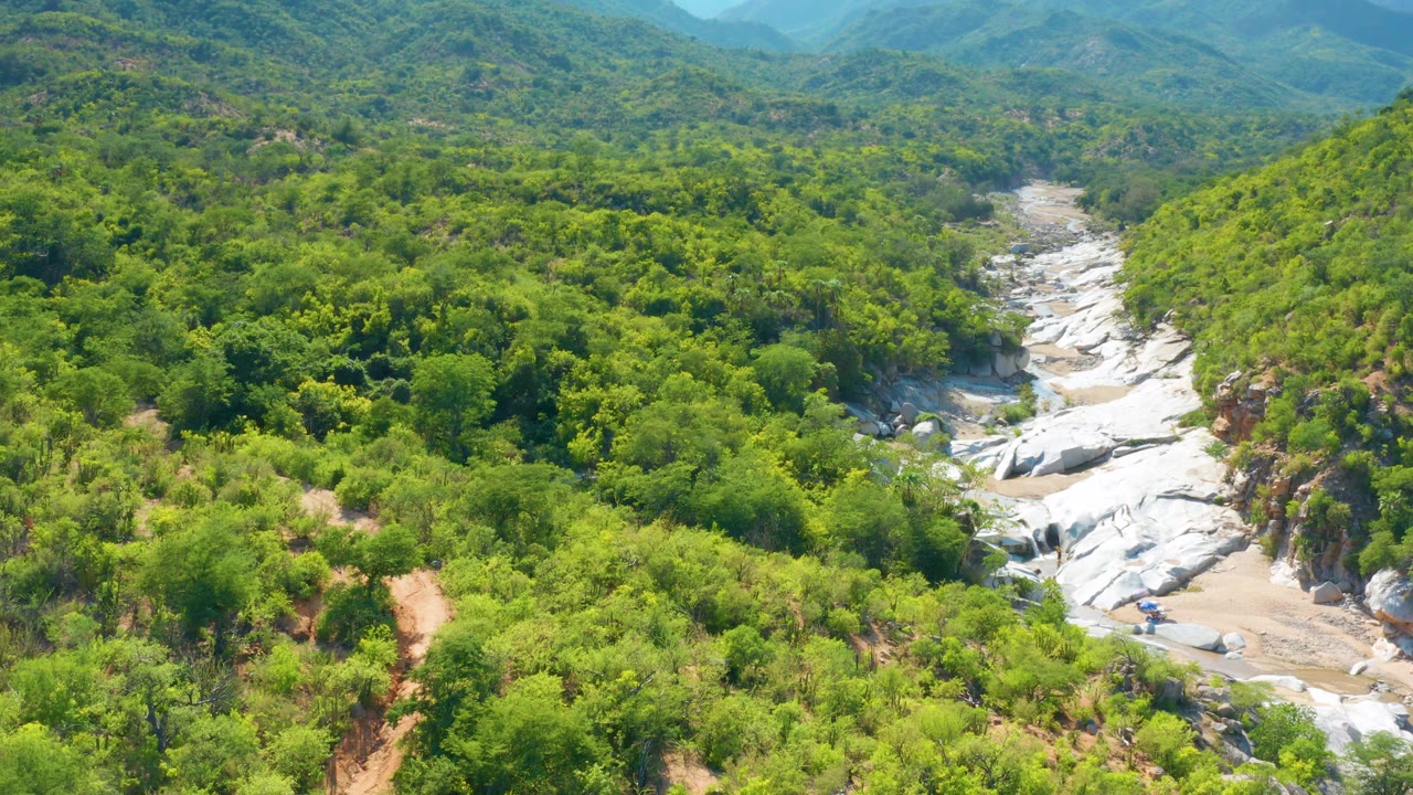 Aerial view of green hills and a pale rocky channel