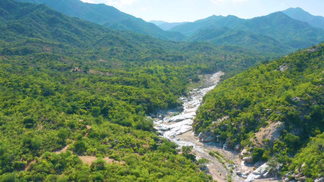 Green hillside valley with pale rocks through the center
