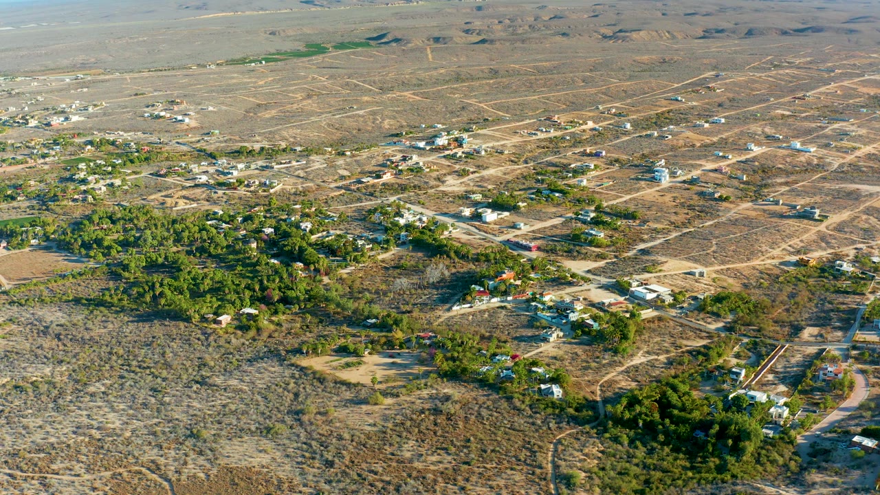 Wide aerial view of desert roads and homes around a green center