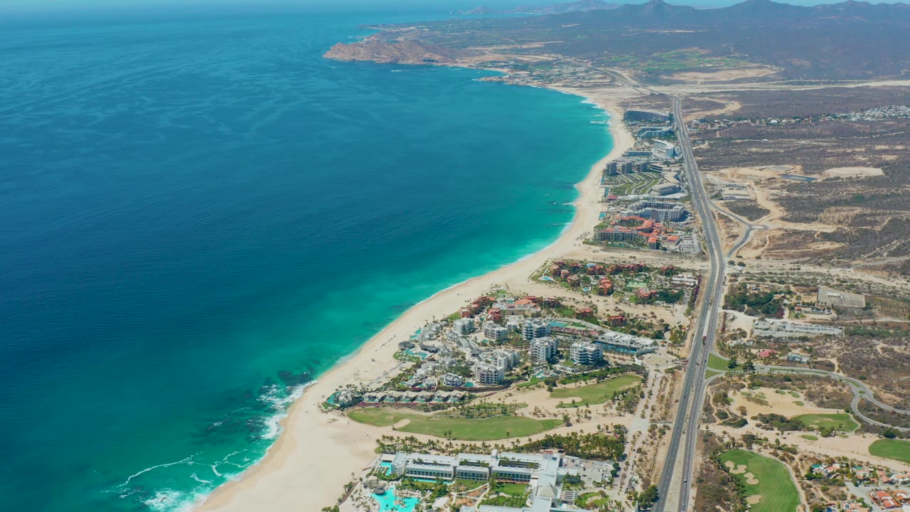 Aerial view of ocean, beach, highway, buildings, and desert terrain