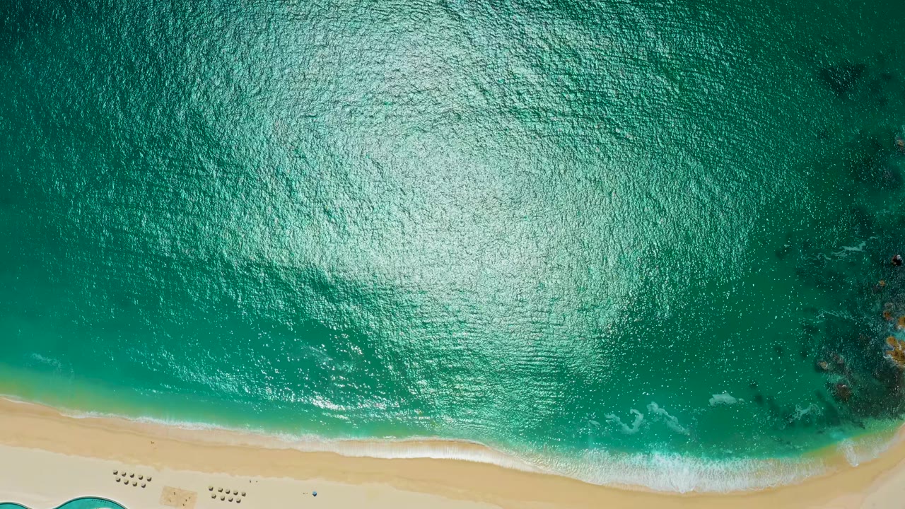 Aerial turquoise water with sand and small shore wash