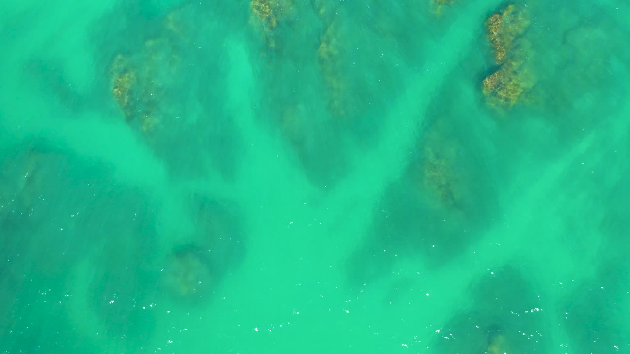 Turquoise ocean floor with darker reef-like patches