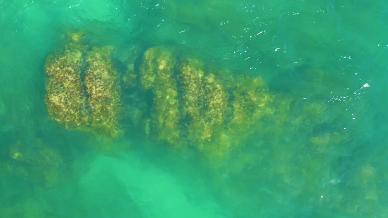 Turquoise water over submerged rock formations.