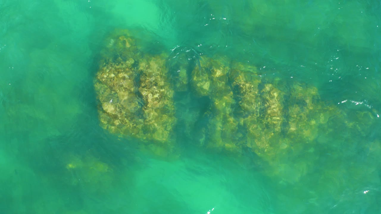 Clear turquoise water over submerged rocks