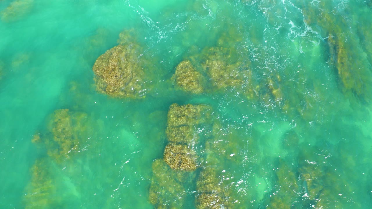 Turquoise ocean water over submerged rocks