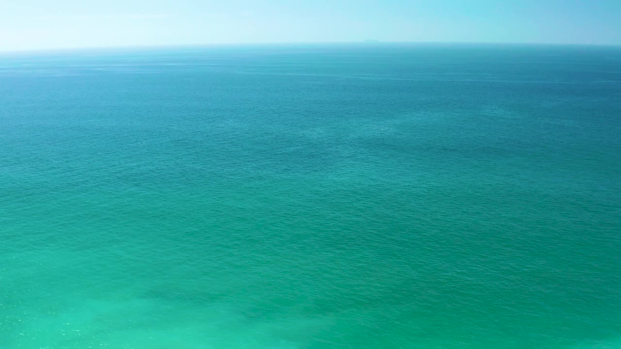 Dreams Los Cabos ocean view with the horizon high in frame, teal water across the foreground, darker blue water in the distance, and no visible people.