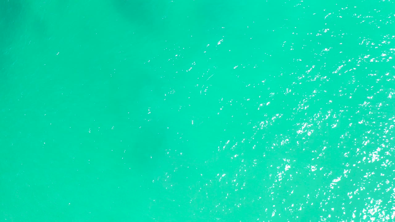 Turquoise ocean surface with bright sun sparkles