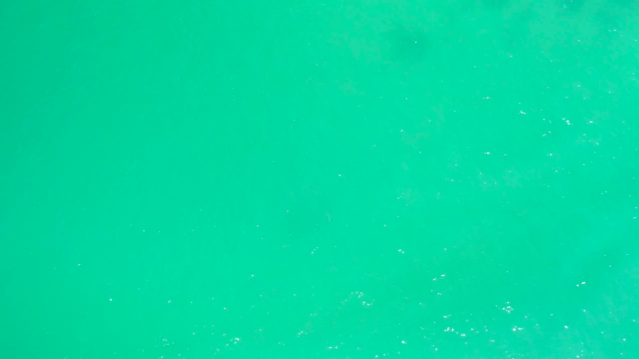 Turquoise water surface with small bright ripples.